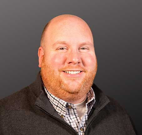 A man wearing a suit and tie smiling at the camera