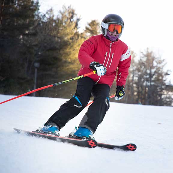 A person riding skis down a snow covered slope