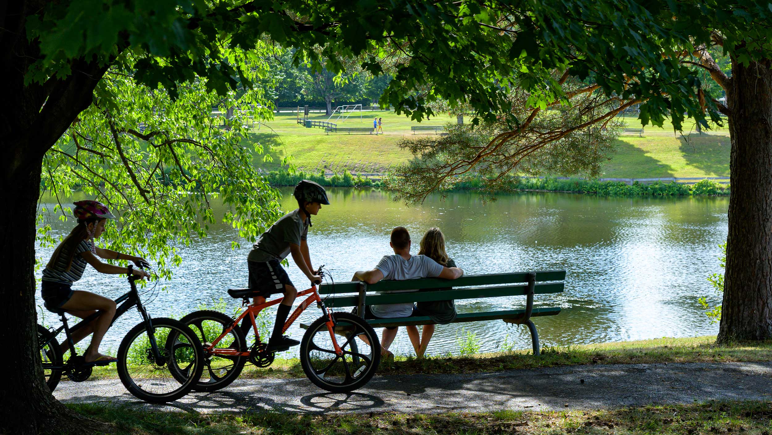 A person sitting on a bench next to a lake